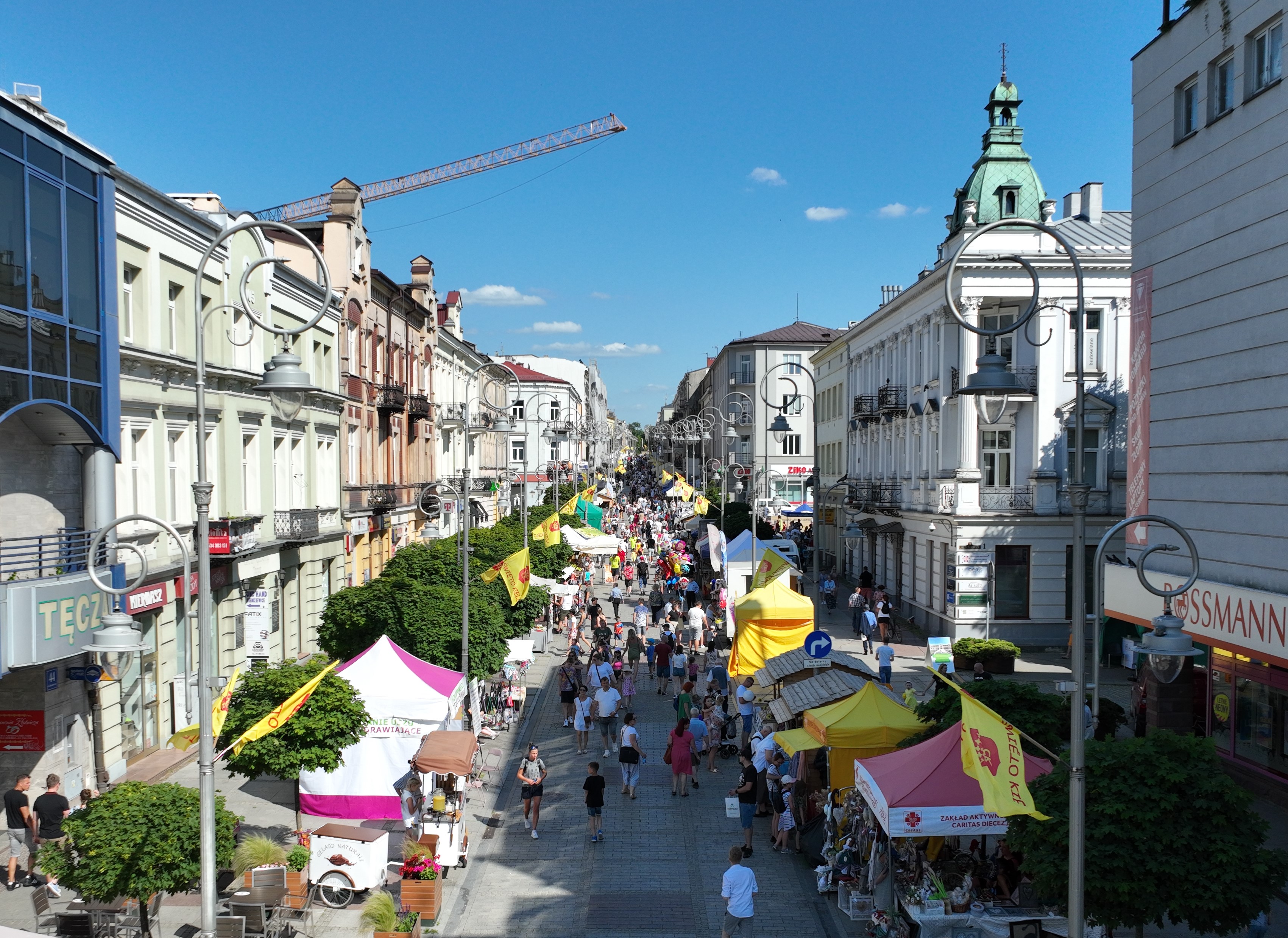 Ulica Sienkiewicza widziana z góry, na której ustawione są stoiska handlowe. Na ulicy jest wiele osób.