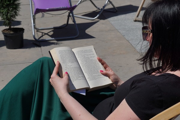 Kobieta czytająca książkę na leżaku