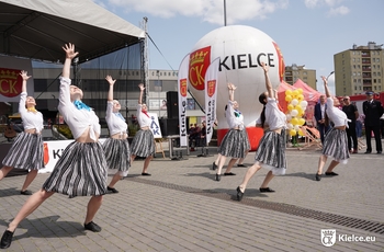 Grupa tancerek przed scena, a w tle balon z herbem Kielc