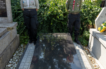 Dwoje harcerzy stojących przy grobie Jerzego Pilcha