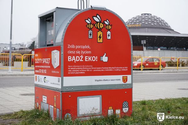 Czerwony Pojemnik na elektroodpady, w tle Dworzec Autobusowy przy ul. Czarnowskiej