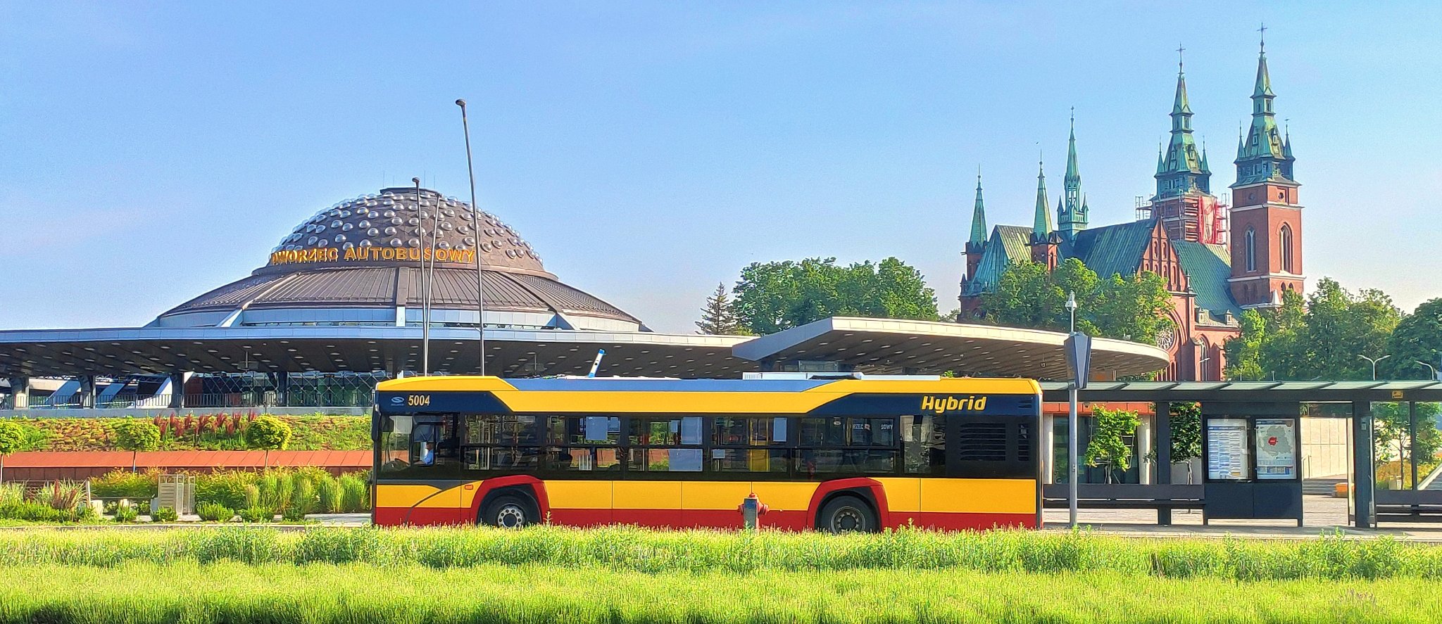 Zdjęcie autobusu, w tle  Dworzec Autobusowy przy ul. Czarnowskiej, przystanek oraz kościół