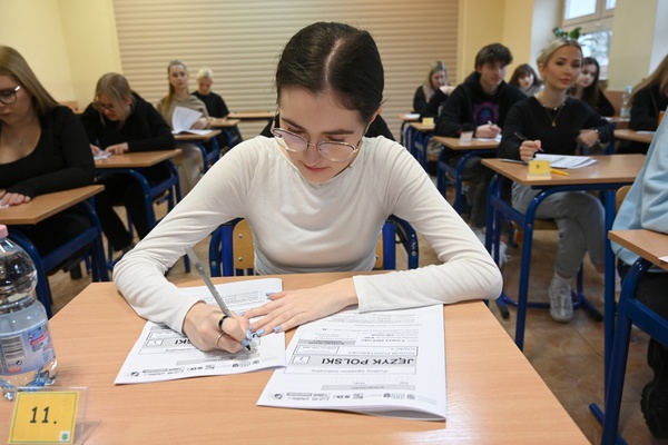 Maturzystka rozwiązująca arkusze egzaminacyjne z języka polskiego