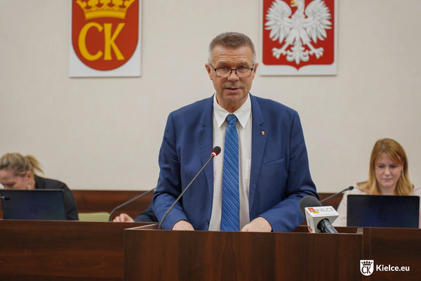 Prezydent Bogdan Wenta stoi przy mównicy na sali sesyjnej.