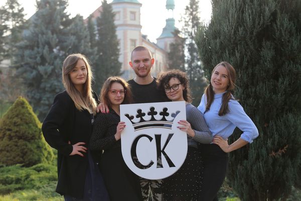 grupa młodych osób trzyma w dłoniach herb Kielc