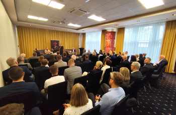 zdjęcie przedstawia ludzi siedzących na sali konferencyjnej. z przodu przemawia prezydentka Kielc, Agata Wojda
