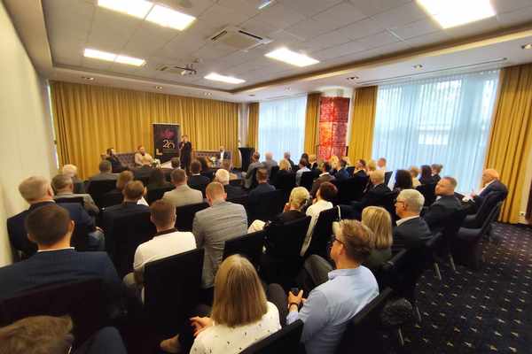 zdjęcie przedstawia ludzi siedzących na sali konferencyjnej. z przodu przemawia prezydentka Kielc, Agata Wojda