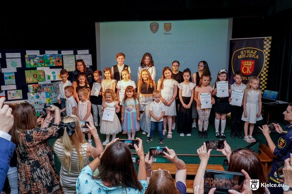 zdjęcie przedstawia laureatów konkursu podczas robienia wspólnego zdjęcia z prezydentką Kielc, Agatą Wojdą