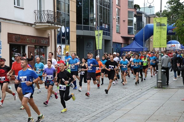 Kilkadziesiąt osób w strojach sportowych biegnie ulicą Sienkiewicza.
