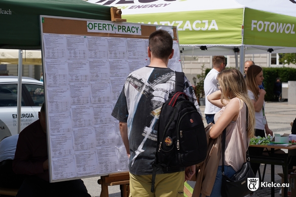 Dwie osoby stoją przy ustawionej na Rynku  tablicy z ofertami pracy