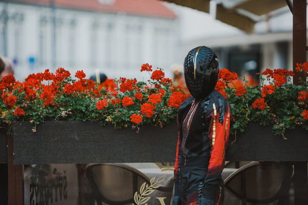 Ludzka postać bez twarzy na tle kwiatów