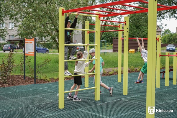 zdjęcie przedstawia dzieci korzystające ze strefy workout; chłopiec wspina się po drabince