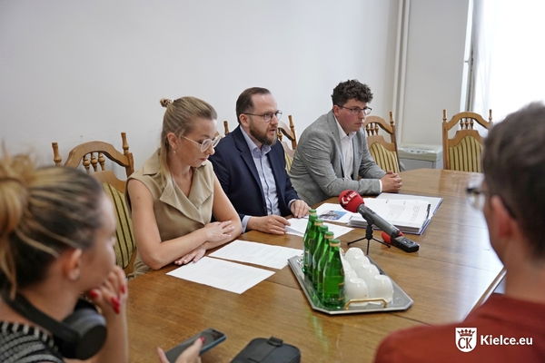 Karol Wilczyński, przewodniczący Rady Miasta wraz z wiceprzewodniczącymi: Anną Mazur-Kałużą i Marcinem Stępniewskim siedzą za stołem zwróceni do dziennikarzy.