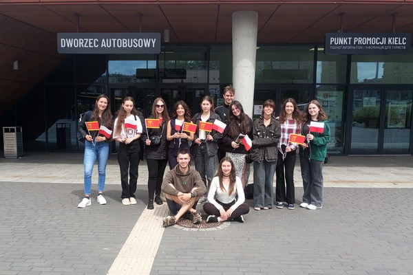 Grupa młodzieży stoi przed budynkiem Dworca Autobusowego w Kielcach