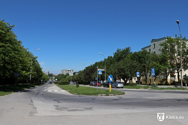 Ulica Bohaterów Warszawy od skrzyżowania z ulicą Szczecińską, pomiędzy jezdniami pas zieleni, po prawej i lewej stronie drzewa.