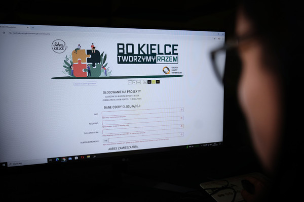 Fragment głowy osoby siedzącej przed monitorem, na monitorze strona Budżetu Obywatelskiego