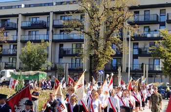 Kilkudziesięciu uczniów idzie ze sztandarami