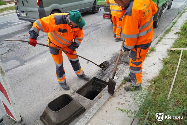 Trzech mężczyzn udrażnia studzienkę kanalizacyjną