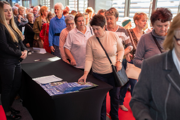 Grupa kilkunastu starszych osób w Centrum Kongresowym Targów Kielce