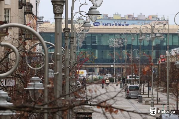 Latarnie ze świetlnymi ozdobami na ul. Sienkiewicza, w tle dworzec kolejowy.