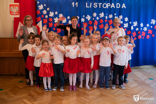 Grupa przedszkolaków i trzy osoby dorosłe pozuje do zdjęcia.