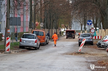 ulica Lecha, środkiem idzie mężczyzna w pomarańczowym kombinezonie, w tle samochód budowy