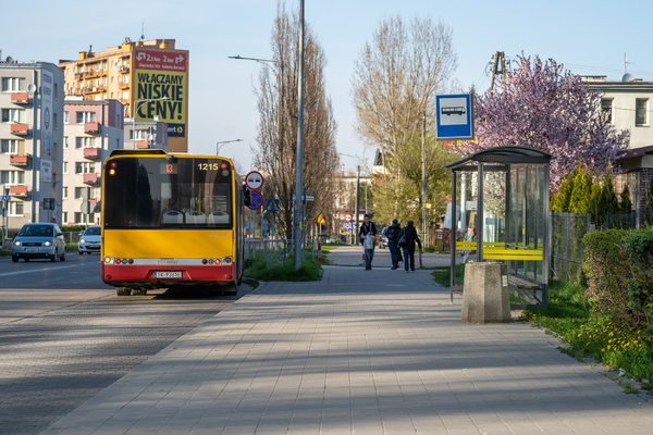 Ulica Jagiellońska, po prawej stronie przystanek, z przystanku odjeżdża autobus, po chodniku idzie kilka osób